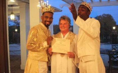 Gail Olberg holding marriage license with newlywed couple